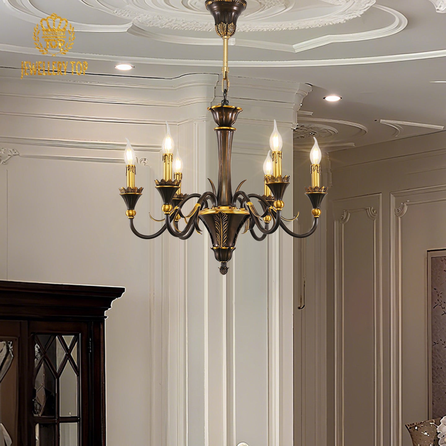 A lit vintage brass living room chandelier installed in a classic interior with a dark door.