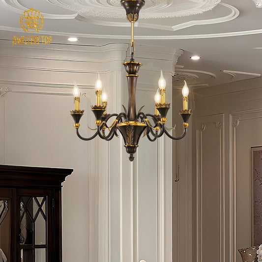 A lit vintage brass living room chandelier installed in a classic interior with a dark door.