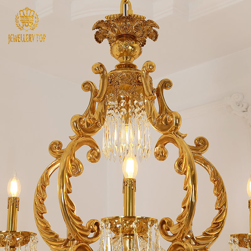 Close-up detail of the chandelier's ornate brass top with floral and scrollwork carvings.