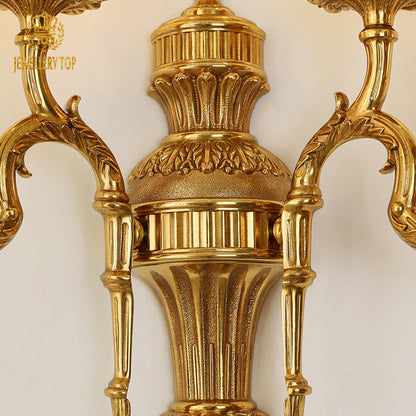 Close-up focus on the sconce's mid-section, highlighting the fluted column and detailed classical patterns.