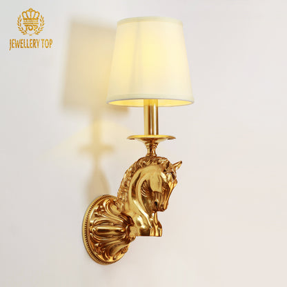 Side view of the brass horse head wall sconce light mounted on a white wall, highlighting the sculptural profile and fabric shade.