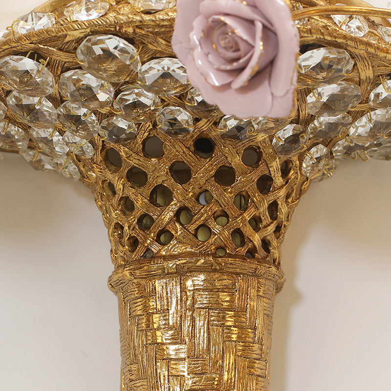 Detailed macro shot of the textured brass basket weave and sparkling crystal embellishments on the floral wall lamp.