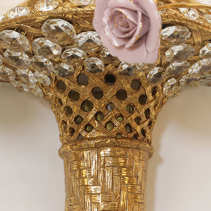 Detailed macro shot of the textured brass basket weave and sparkling crystal embellishments on the floral wall lamp.