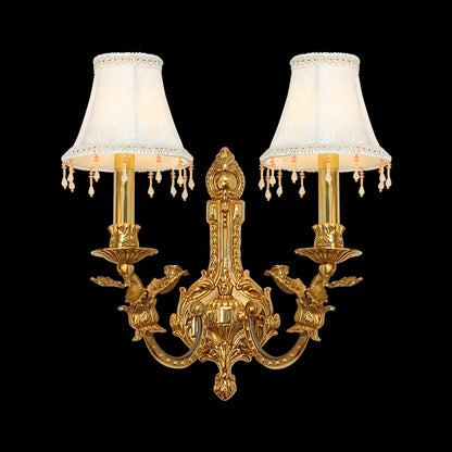Front product view of the Hôtel de Lune golden brass wall sconce with lace-trimmed shades and crystal fringes on a black background.
