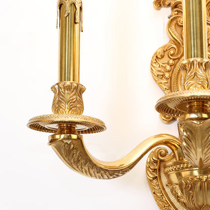 Extreme close-up macro detail of the sconce’s hand-chased floral and scroll patterns on the central brass column.