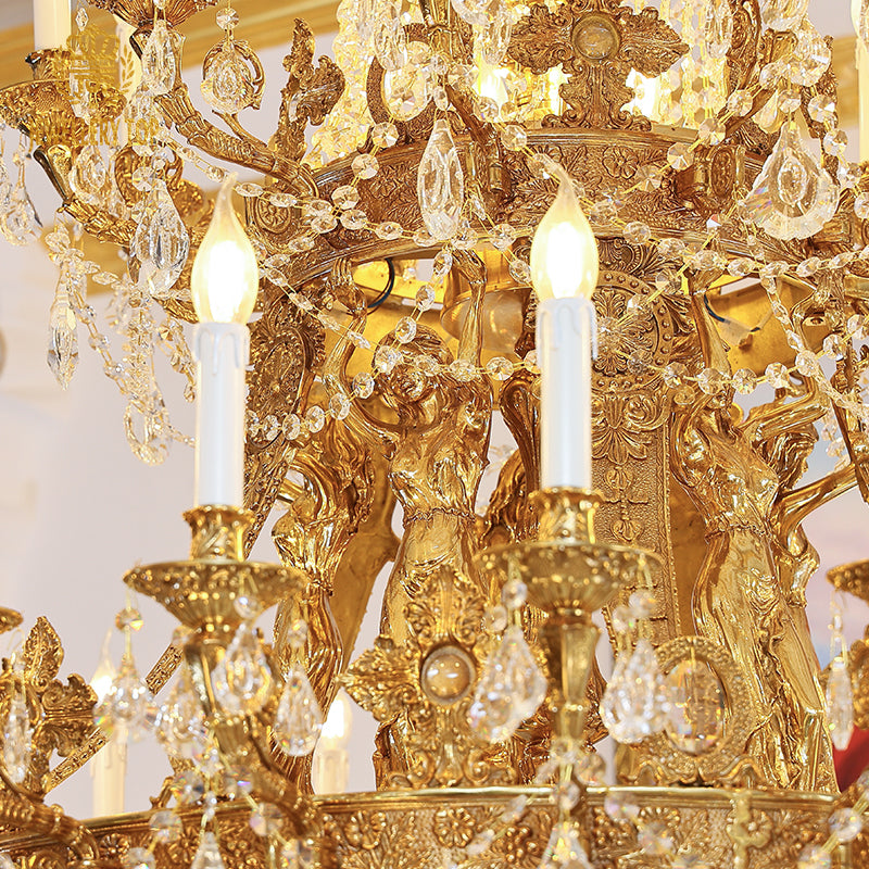 Macro shot of ornate brass scrollwork, candle bulbs, and crystal pendants on a luxury chandelier.