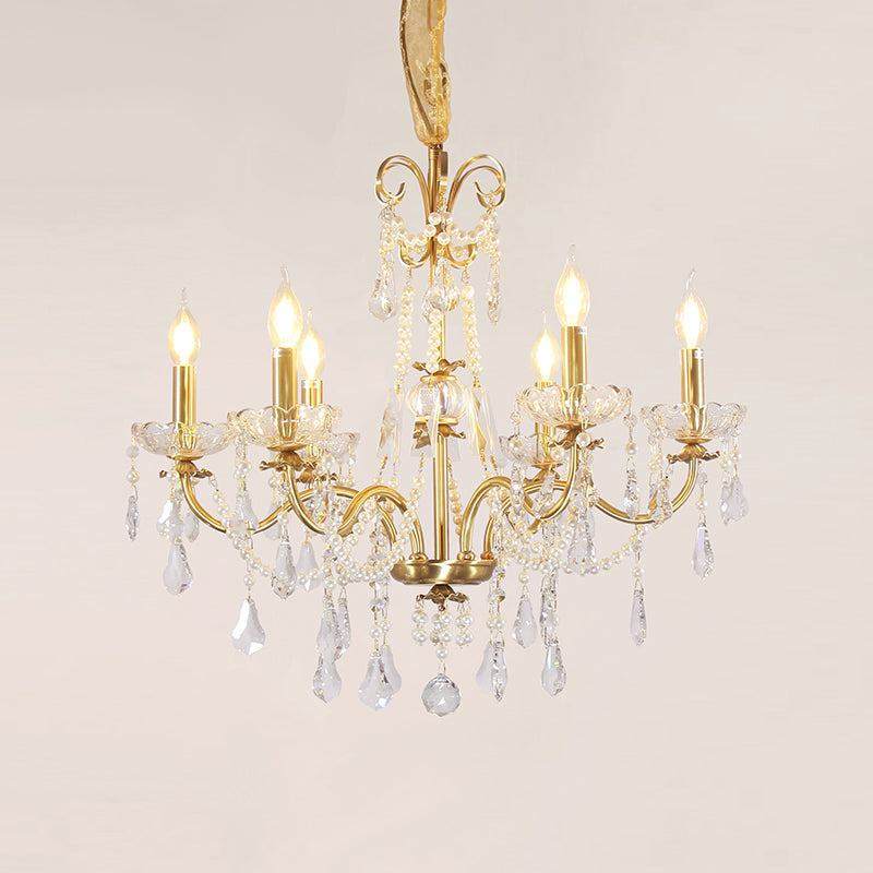 Macro close-up of the finely detailed golden ribbon-like volutes and the precision-cut crystal teardrop pendants.
