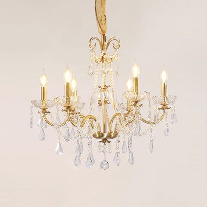 Macro close-up of the finely detailed golden ribbon-like volutes and the precision-cut crystal teardrop pendants.