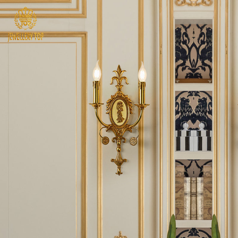 Front view of the French brass wall sconce with two candle bulbs, mounted on a light wall with gold trim.