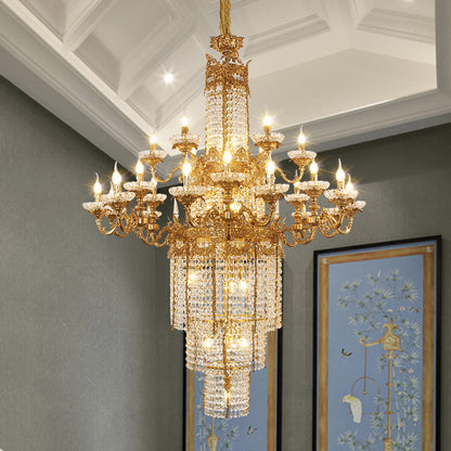 The luxury brass crystal chandelier installed in a room with coffered ceiling and artwork.