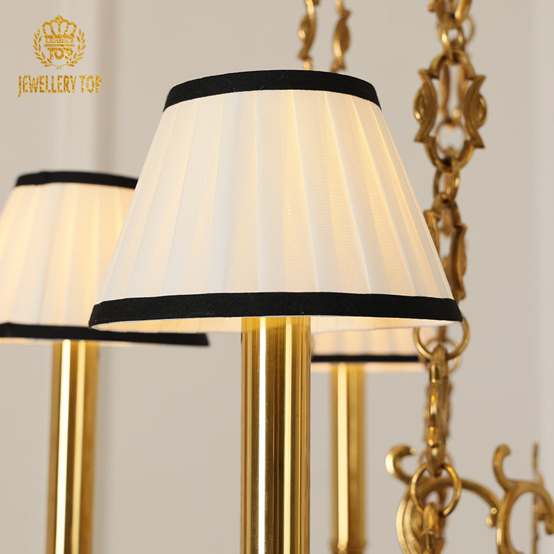 Three JEWELLERY TOP classical brass chandeliers with white shades against a neutral background.