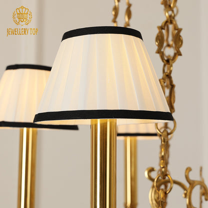 Three JEWELLERY TOP classical brass chandeliers with white shades against a neutral background.