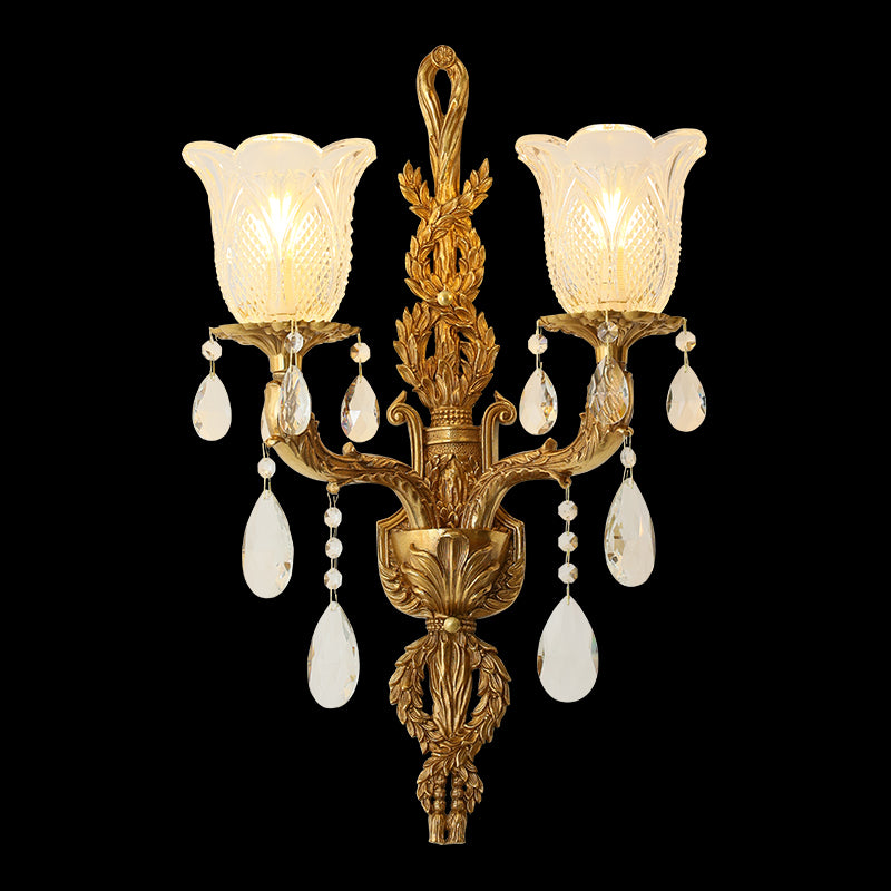 Close-up detail of the golden Floral Cascade brass wall sconce with ornate leaf carvings and crystal bead fringe, JEWELLERY TOP branding.