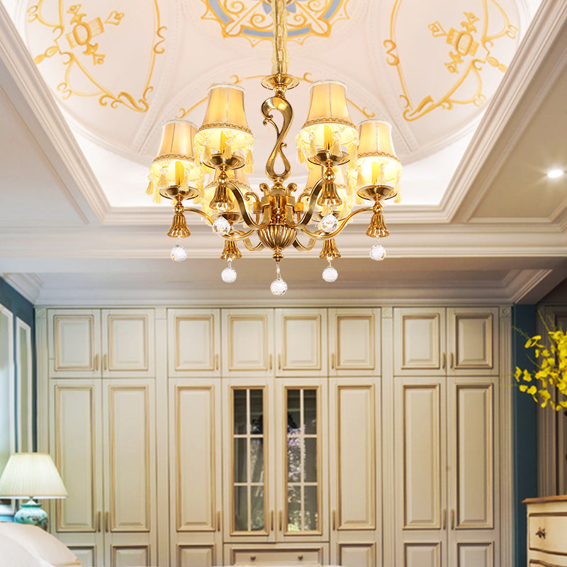 European brass chandelier installed in a luxurious bedroom with a white coffered ceiling.