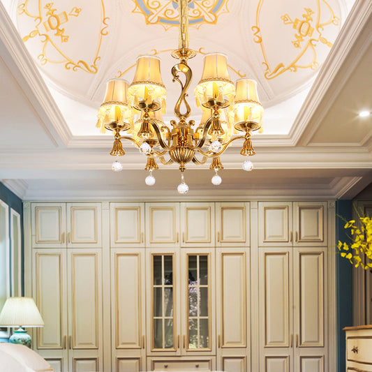 European brass chandelier installed in a luxurious bedroom with a white coffered ceiling.