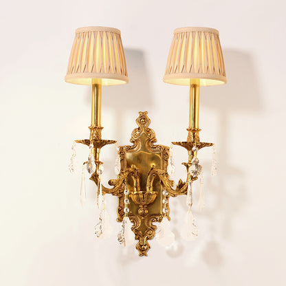 The decorative wall lamp with pleated fabric lampshades installed on a clean white wall, emitting a soft warm glow.