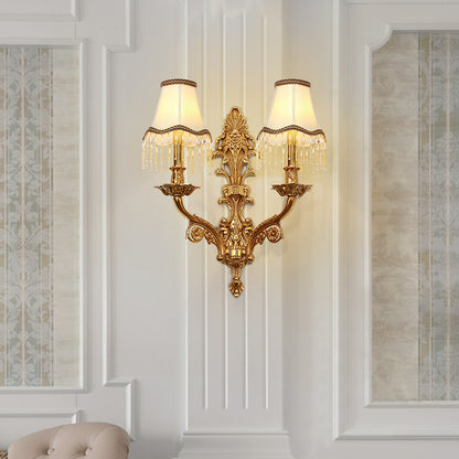 The installed French brass wall lamp on a white wainscoted wall, emitting a warm glow in a classic interior setting.