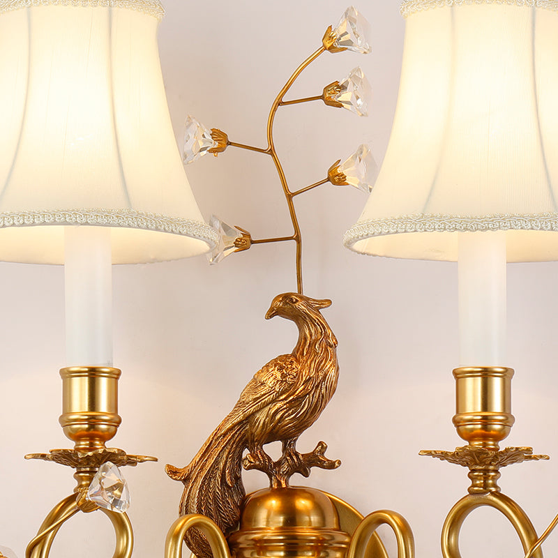 Macro shot of the crystal-accented brass leaves and the sparkling droplet pendants on the wall lamp.