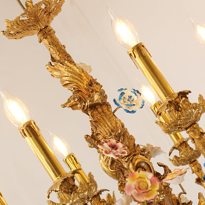 Macro close-up of a pink and white ceramic rose and a blue flower on a brass chandelier arm.