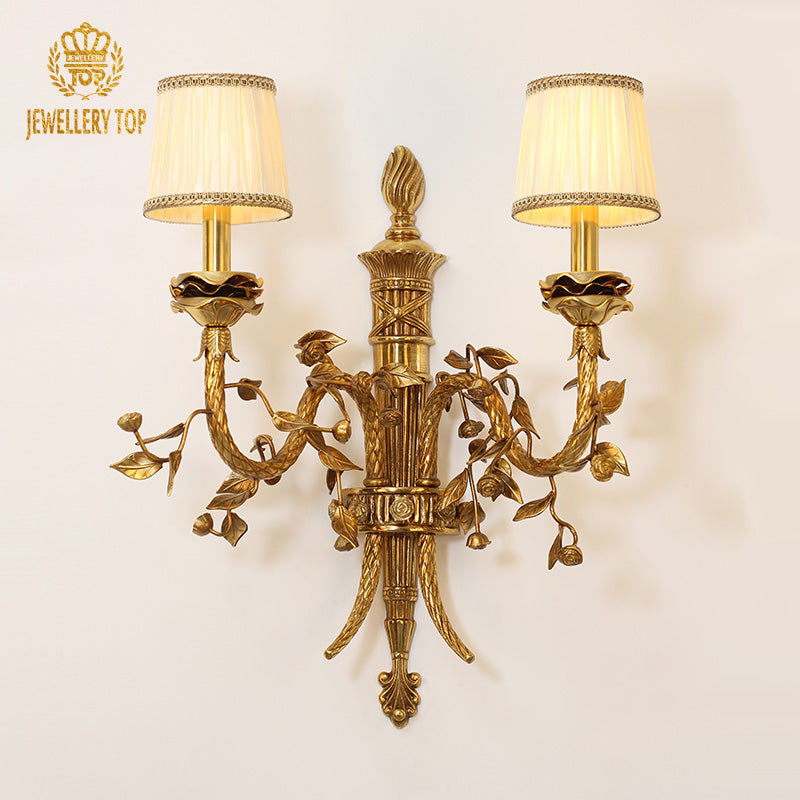 Branded close-up of the ornate golden brass sconce, showcasing intricate grape, leaf, and floral carvings.