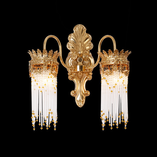 Éventail Baroque dual-arm brass wall sconce with a central fan ornament and crystal bead fringe on a black background.