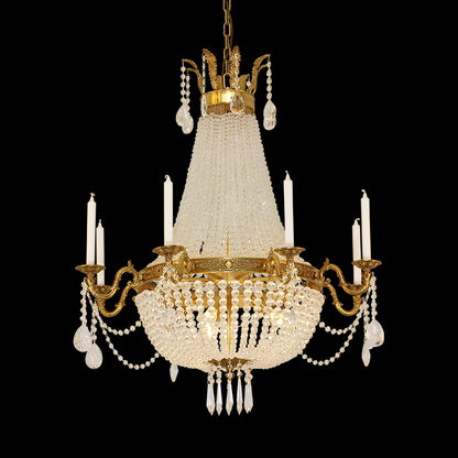 French Baroque brass chandelier with a conical crystal centerpiece, isolated on black.