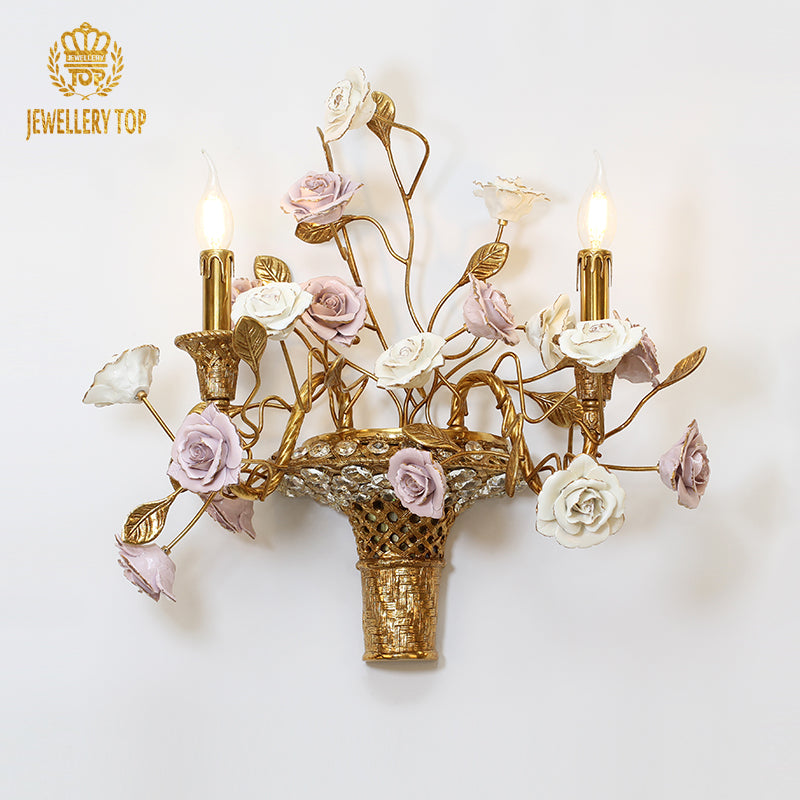 Front view of the JEWELLERY TOP Floral Basketry Brass Wall Lamp with ceramic flowers and crystal details on a dark background.