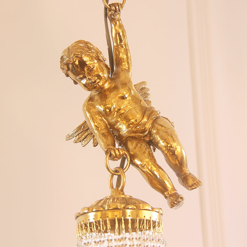 Detailed side view of a brass cherub figurine climbing a chain, with crystal fringe.