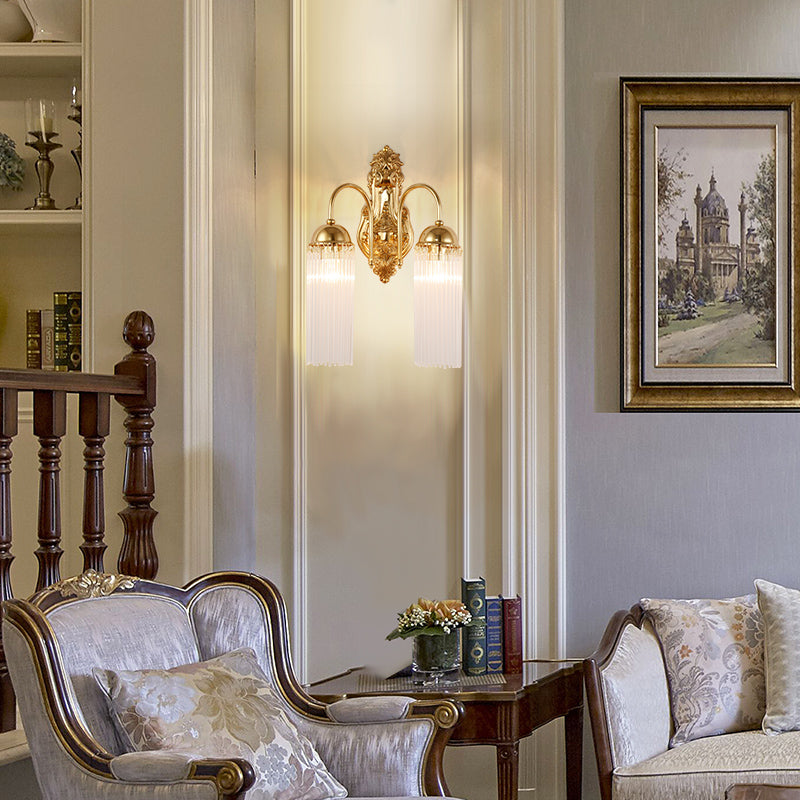 The vintage brass wall lamp installed on a classic white wall with decorative molding.