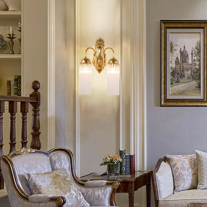 The vintage brass wall lamp installed on a classic white wall with decorative molding.
