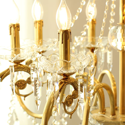 Macro close-up of a single brass arm, glass candle cup, and hanging crystal teardrops.