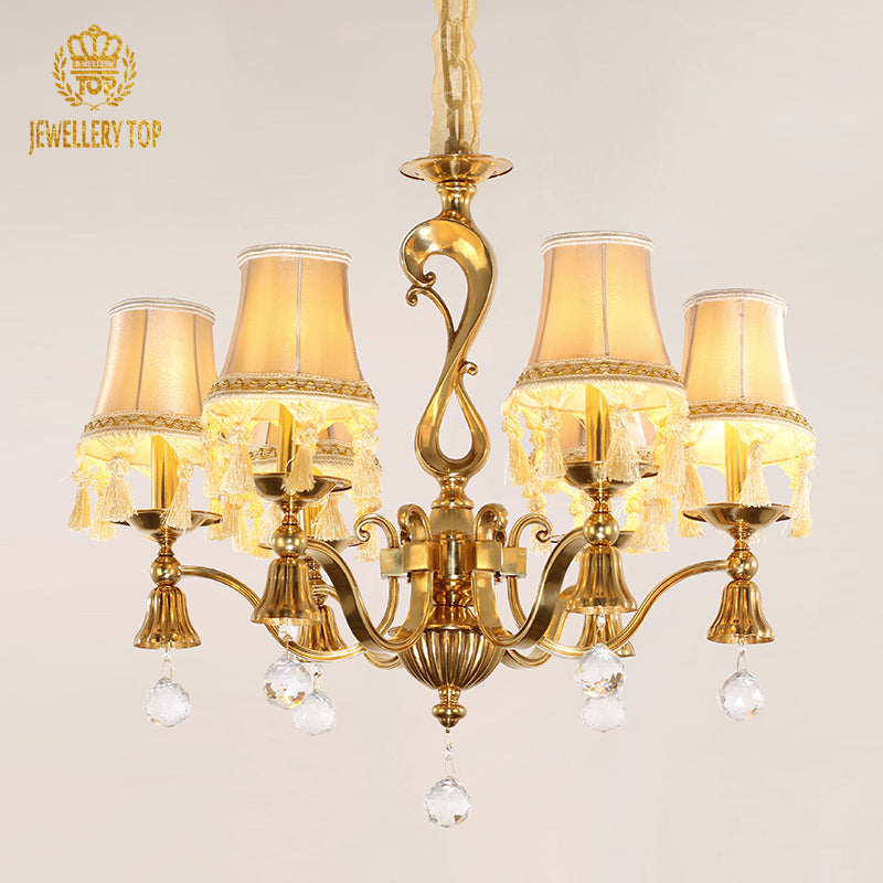 Front view of the JEWELLERY TOP brass chandelier showcasing pleated fabric lampshades and tassels.