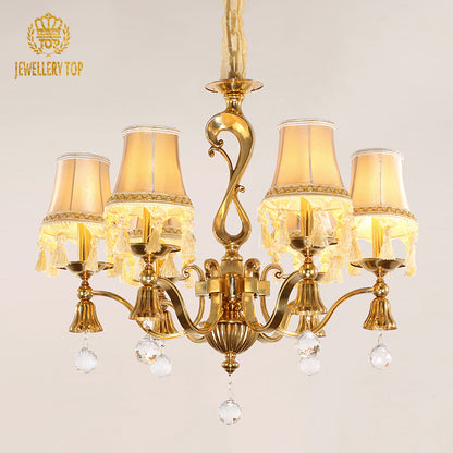 Front view of the JEWELLERY TOP brass chandelier showcasing pleated fabric lampshades and tassels.