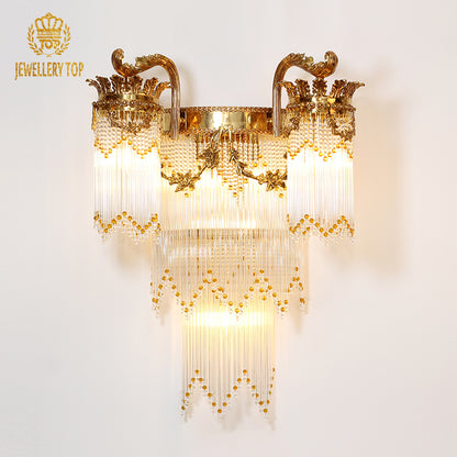 JEWELLERY TOP branded designer wall sconce, showcasing golden arched arms and layered crystal strands on a white backdrop.
