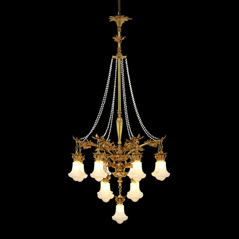 A golden antique brass chandelier with multiple pearl bead curtains, isolated on black.