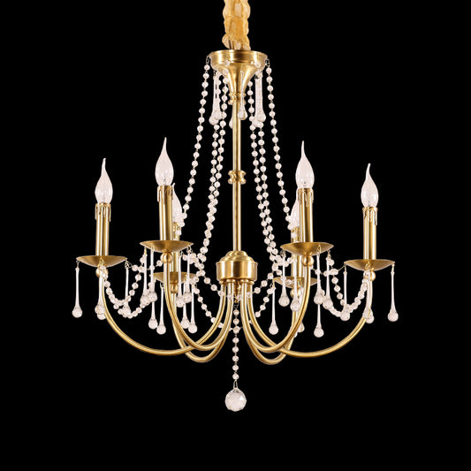 Full-length studio shot of the French Empire simplified elegance brass and crystal chandelier glowing against a stark black background.