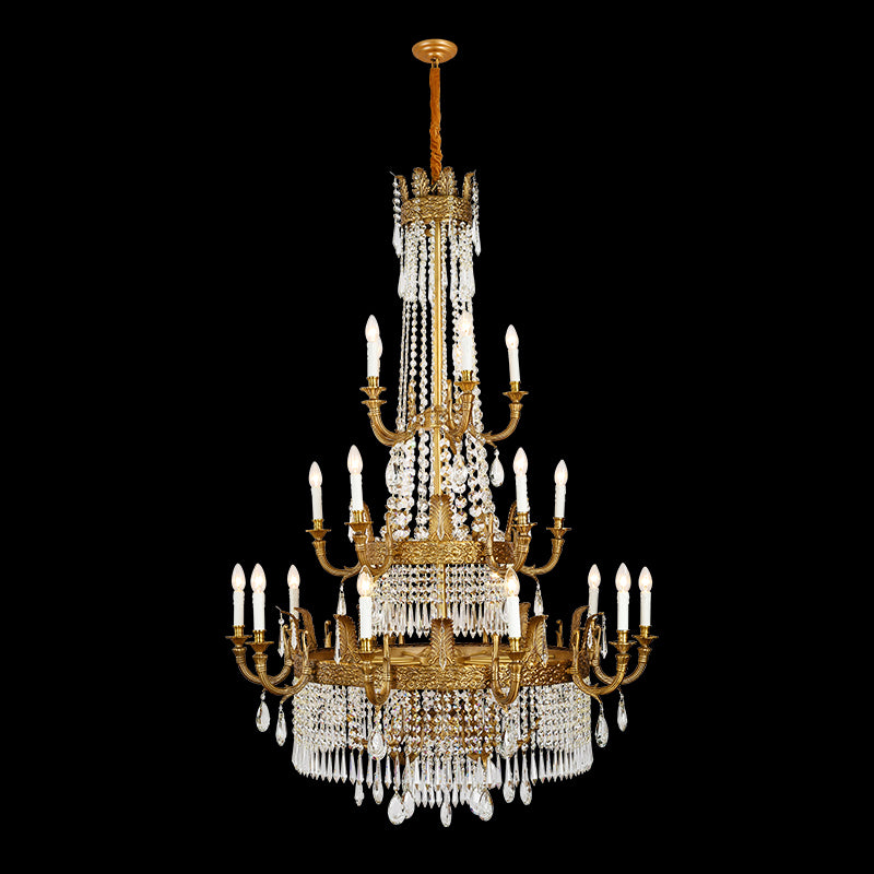 Detailed view of a brass chandelier’s curved arms, candle lights, and waterfall crystal drops.