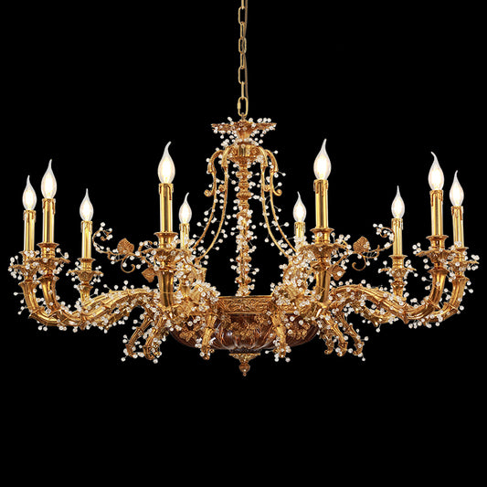 A golden brass chandelier with winding arms and crystal beads, isolated on a black background.