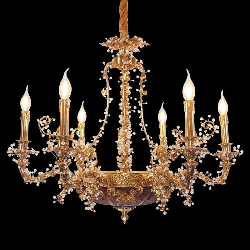 A luxury brass chandelier with a circular base, crystal fringes, and glowing candle-style lights.
