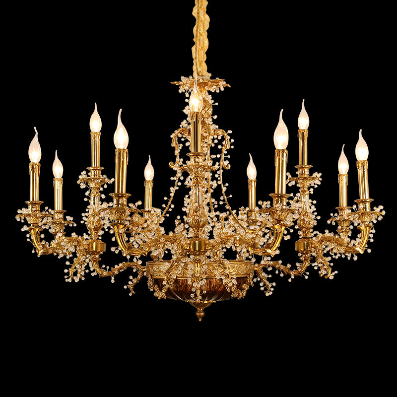 Close-up front view of an ornate brass chandelier with crystal strands and candle bulbs on black.