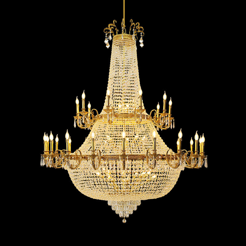 Full-length studio shot of the French Royal Versailles Crystal Column brass chandelier glowing against a stark black background.