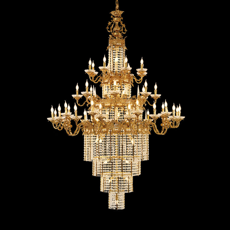 A grand golden brass chandelier with stepped crystal layers, isolated on black background.