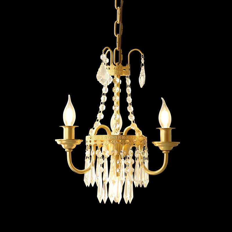 Ornate brass chandelier with crystal drops and candle lights, suspended by a dark chain.