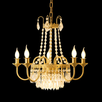 Close-up of a luxury brass chandelier with a central crystal cluster and six glowing bulbs.