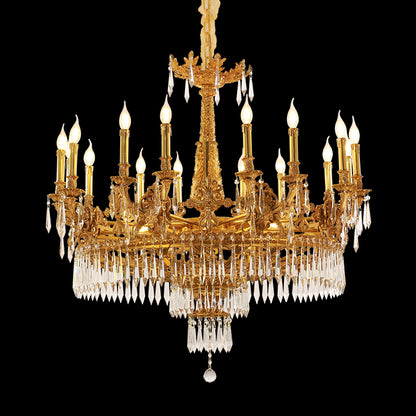 A grand multi-tiered brass chandelier with elaborate crystal pendants against a black background.