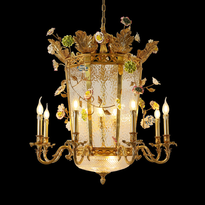 Full studio shot of the French Empire style enamel floral solid brass lantern chandelier glowing against a stark black background.