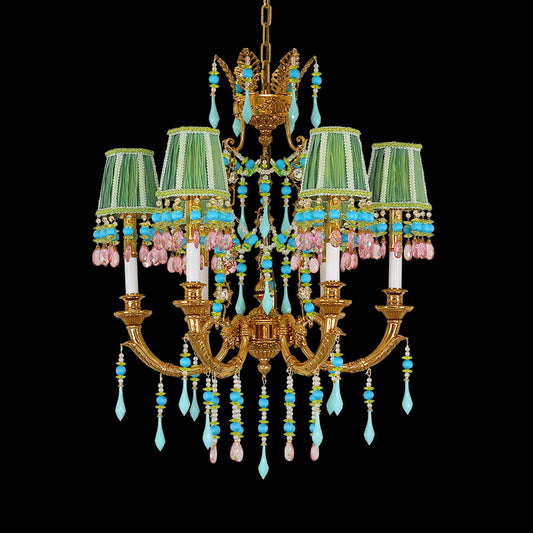 A vintage brass chandelier with multi-colored fabric shades and crystal beads on black background.