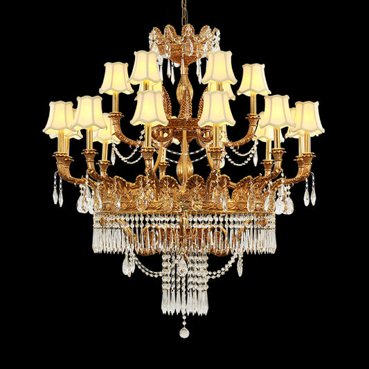 A multi-tiered luxury brass chandelier with fabric shades and crystal on black, front view.