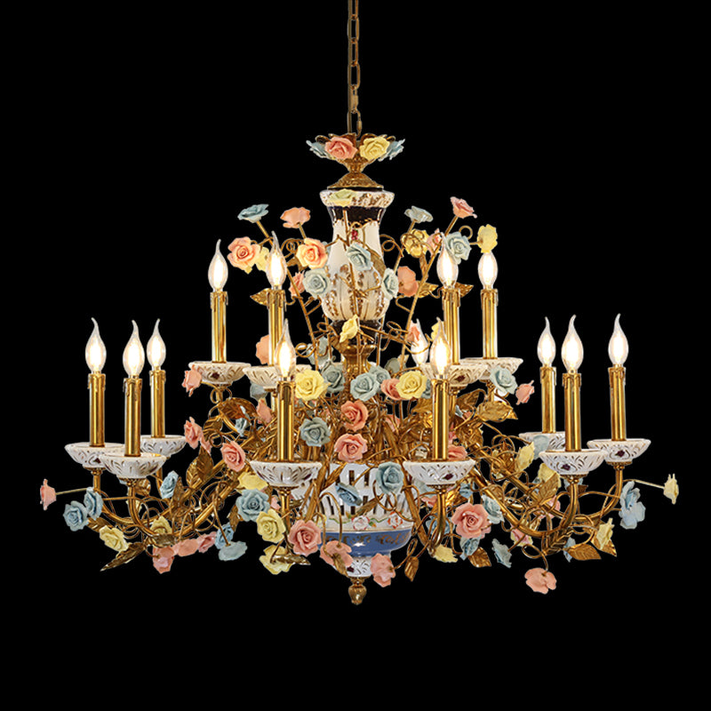 Full-length studio shot of the French Majolica Rose Garden porcelain floral brass chandelier glowing against a stark black background.