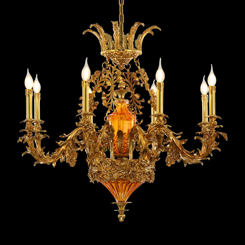Detailed perspective of the ornate brass column, orange glass, and candle arms of the chandelier.